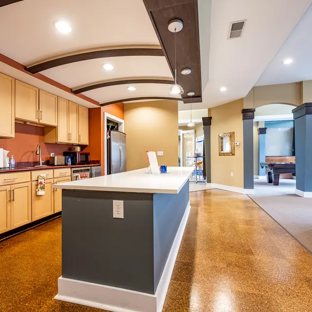 Interior view of a modern kitchen featuring wooden cabinets, a central island, and an open layout
