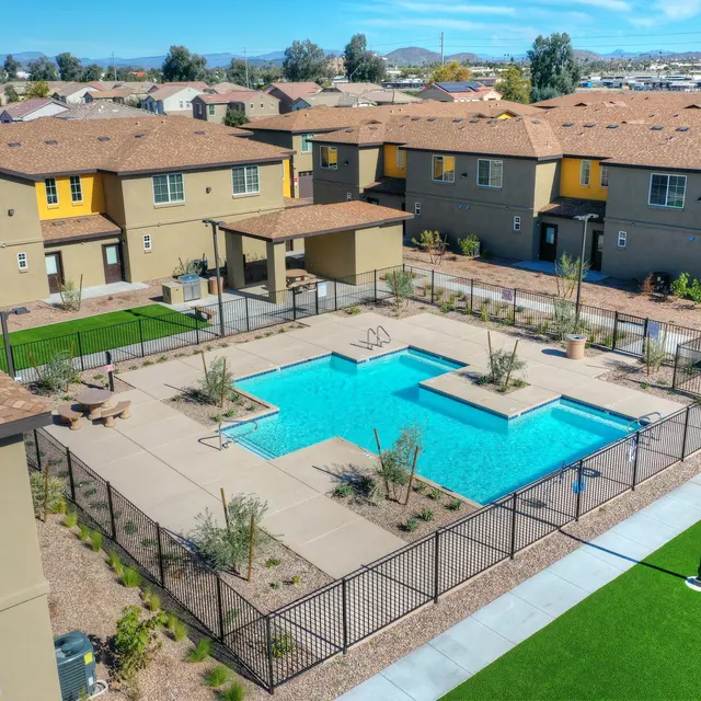 Aerial View of Community Pool Area Aerial view of a community pool area surrounded by residential buildings, featuring a rectangular pool, lounge areas, and landscaping.