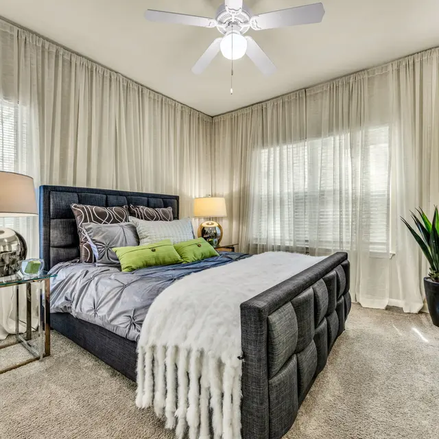 Cozy Modern Bedroom Design Apartment bedroom with a ceiling fan and large window at Agave at South Congress.
