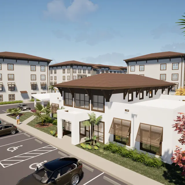 A modern housing development featuring multiple buildings with a mix of three and four stories, surrounded by lush landscaping and parked cars.