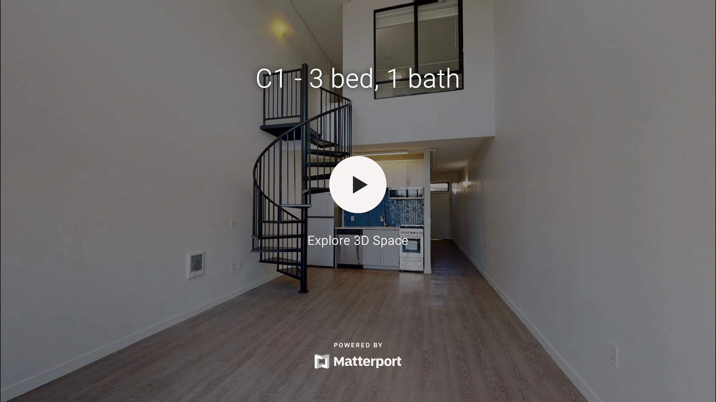 Interior of an apartment featuring a spiral staircase and an open space layout.