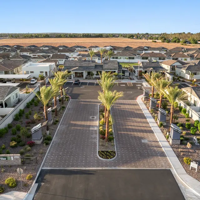 Suburban Community Aerial View Aerial view of a suburban community featuring modern homes with palm trees and well-maintained landscaping.