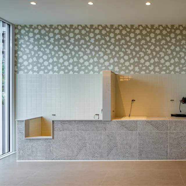 Interior view of a modern kitchen with patterned wallpaper and open shelving