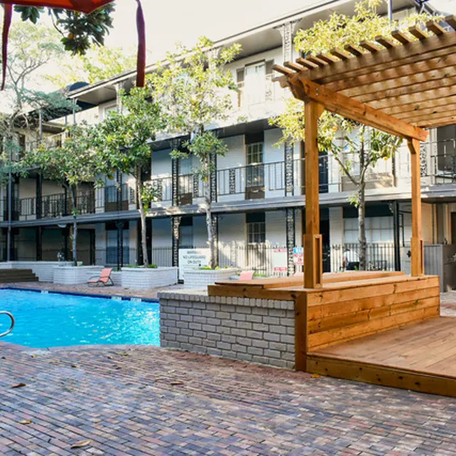 Apartment Complex Pool Area View of an apartment complex pool area with a wooden deck and surrounding seating.