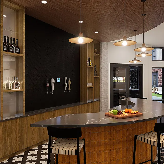 A modern kitchen bar area with a curved wooden counter, bar stools, and decorative shelves displaying bottles and kitchenware. The floor features a decorative black and white pattern, and there are hanging lights overhead.