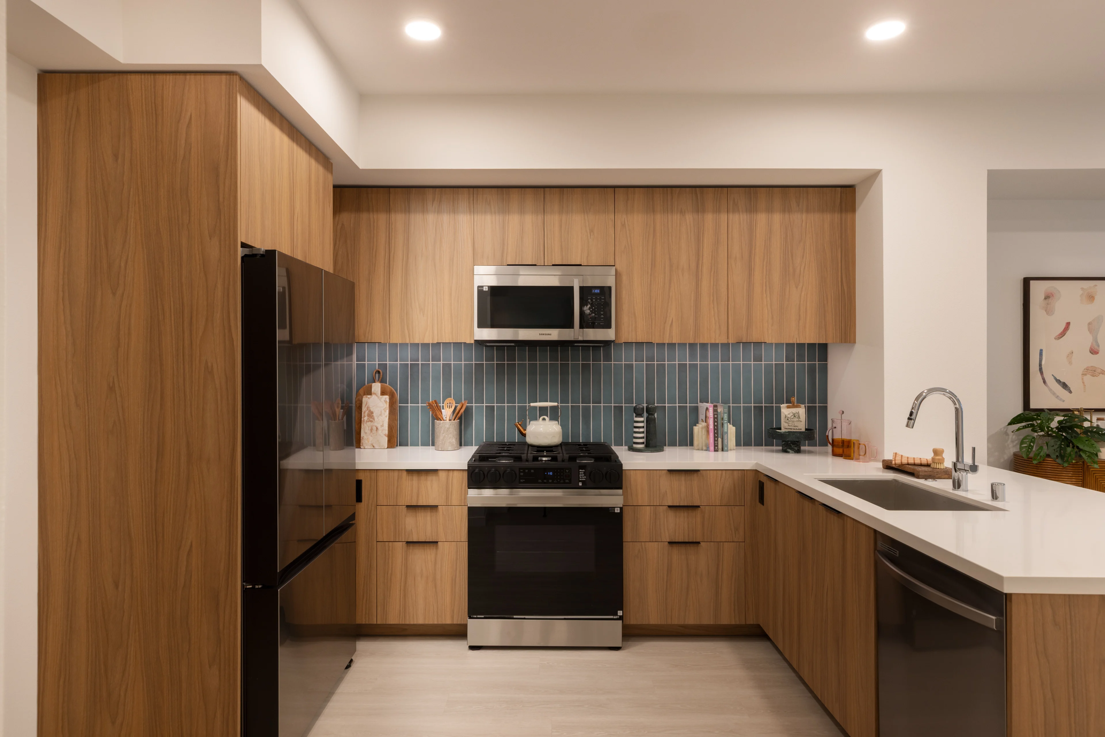 Stylish Modern Kitchen Contemporary kitchen with wooden cabinetry, stainless steel appliances, and a blue tiled backsplash.