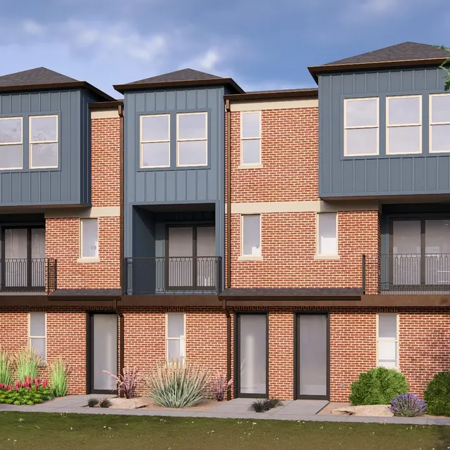 A row of modern townhouses featuring a blend of brick and blue metal facades, with balconies and landscaping including shrubs and small trees.