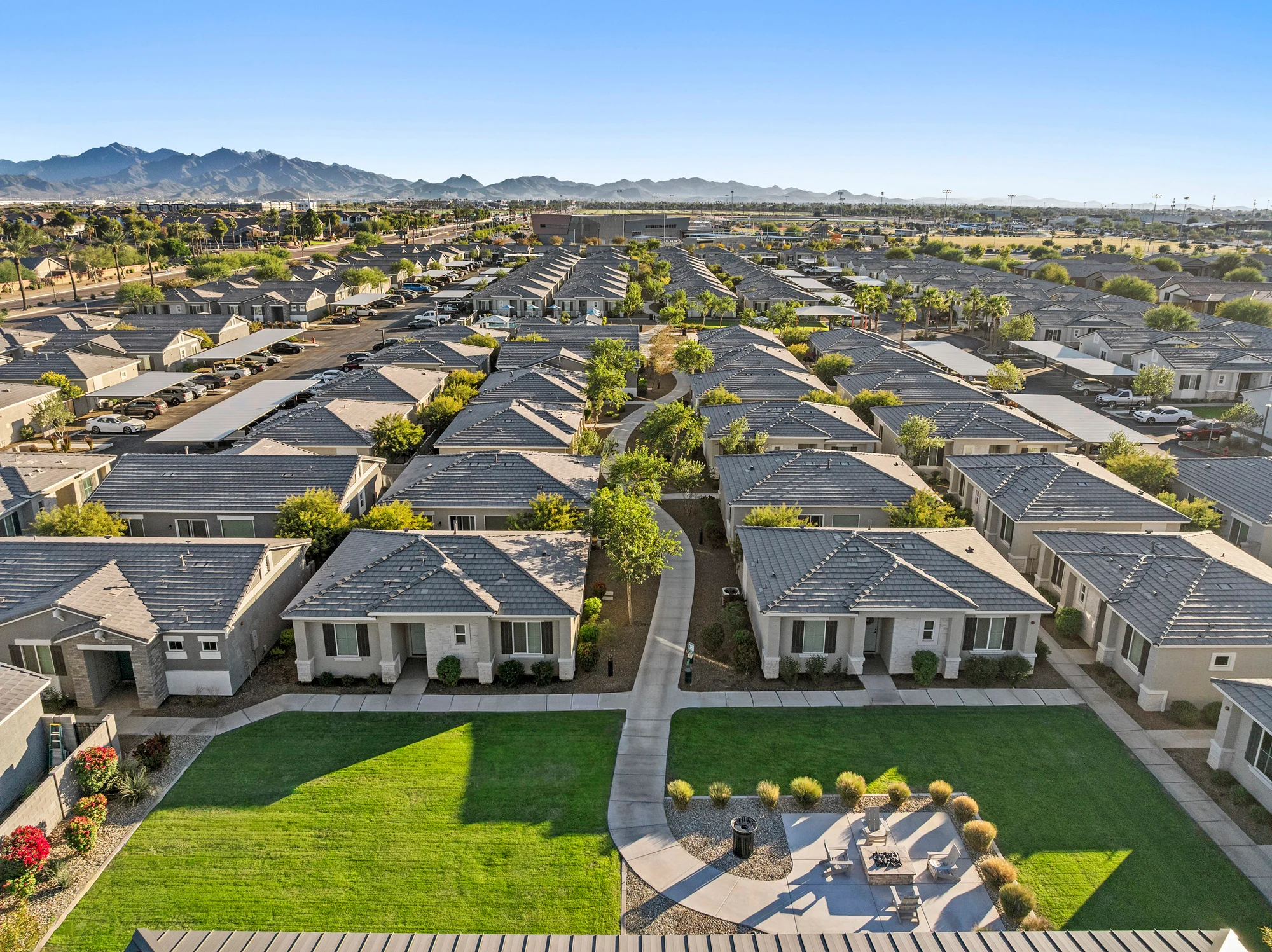 Aerial view of a residential community with numerous houses and green landscaping.