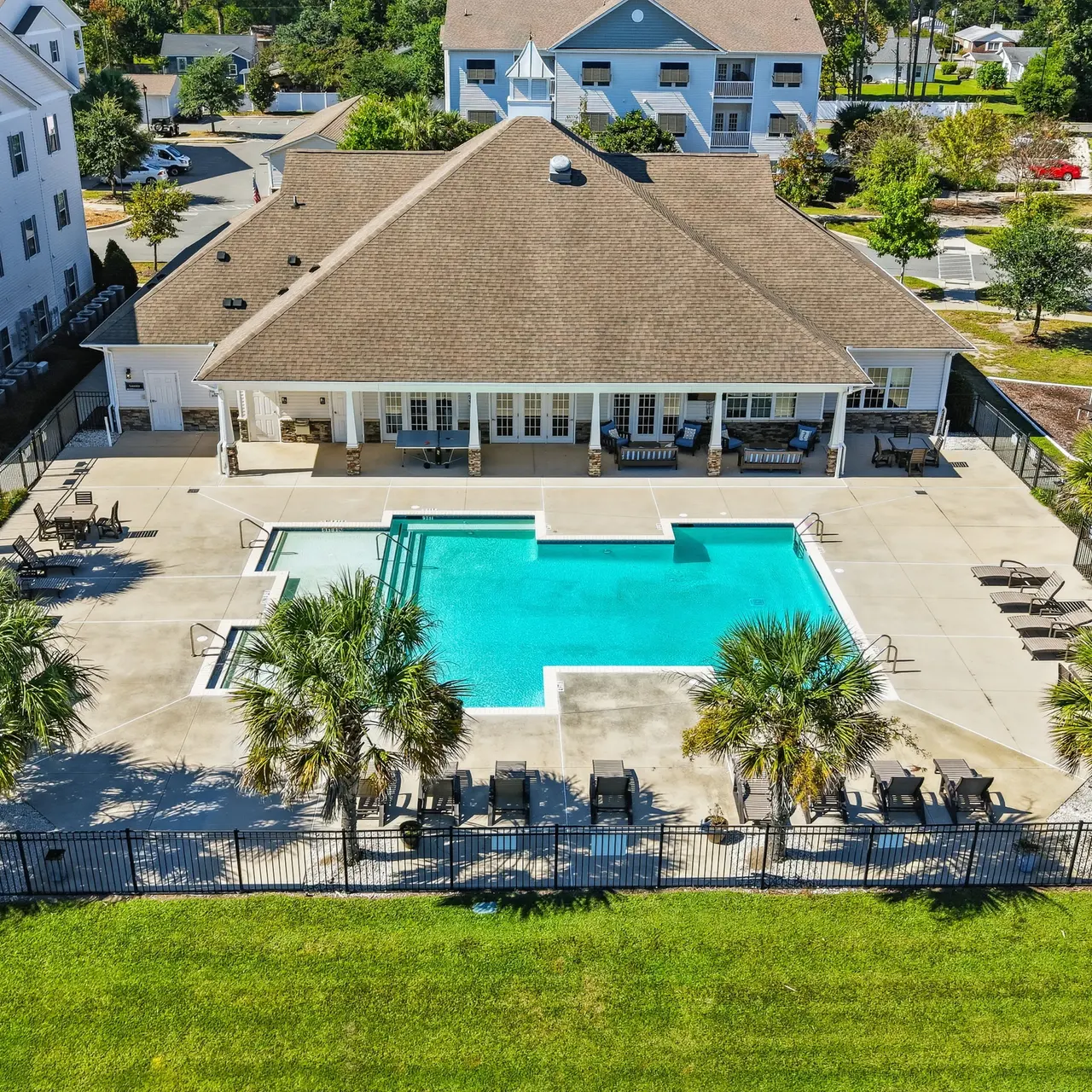 Apartment Complex Pool Area Aerial view of an apartment complex featuring a swimming pool and surrounding palm trees.