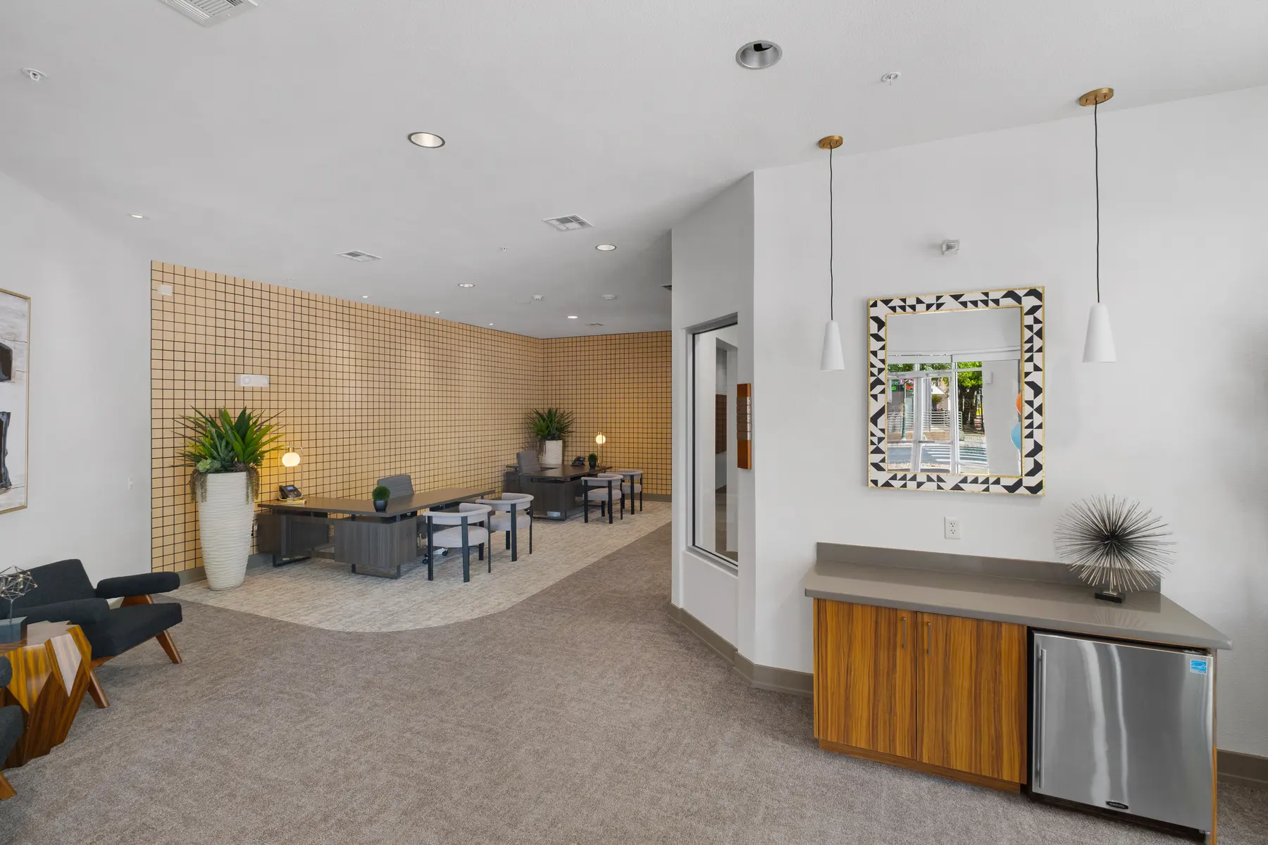 A cozy lounge area with seating and a decorative wall in a community space.