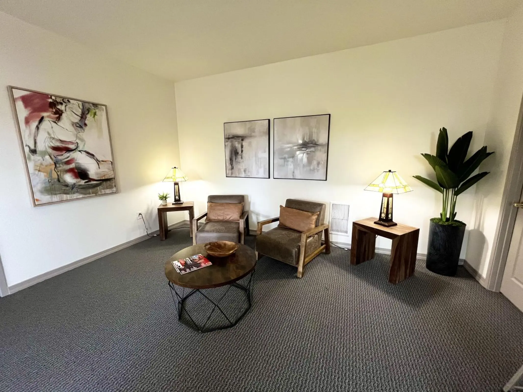 Seating room with two chairs,small table and artwork.