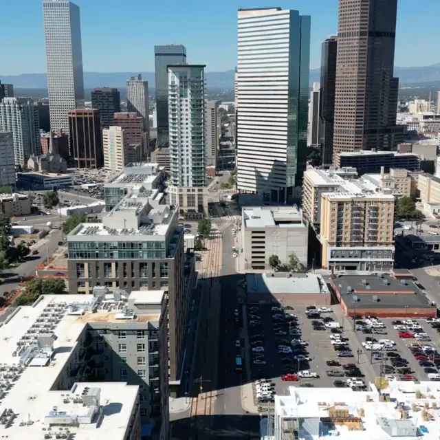 Aerial view of a downtown city skyline with various skyscrapers and low-rise buildings, showcasing urban life and infrastructure.