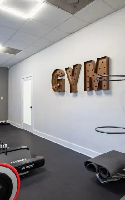 A modern home gym featuring exercise equipment and colorful medicine balls on a rack.