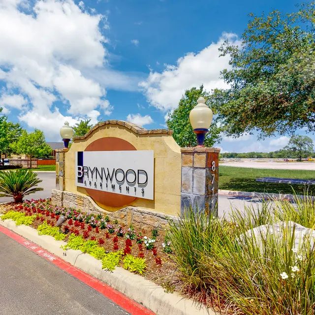 Entrance sign of Brynwood Apartments with landscaped flower beds