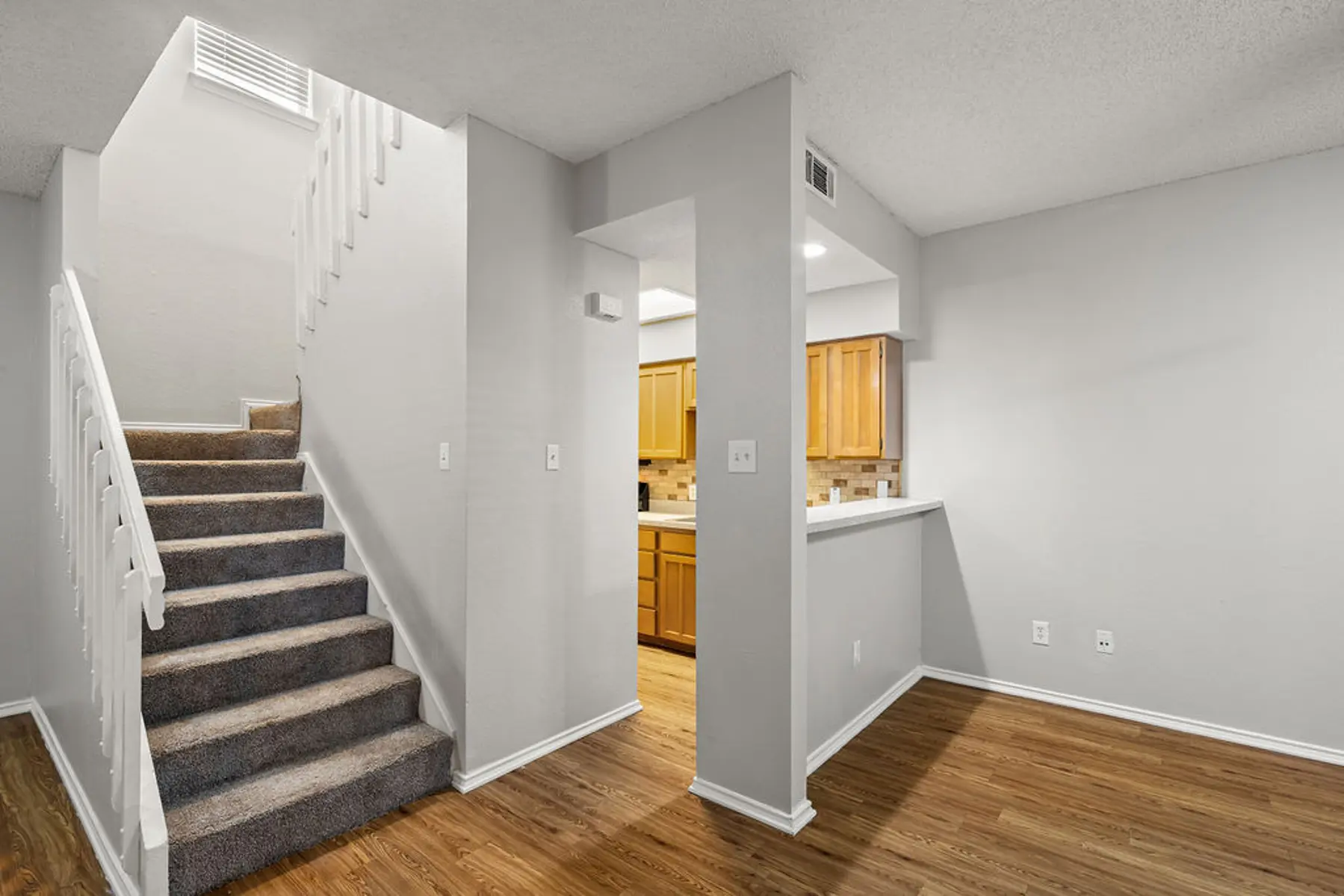 Interior View with Staircase and Kitchen Interior view showing a staircase leading to an upper level, with a kitchen area visible in the background.