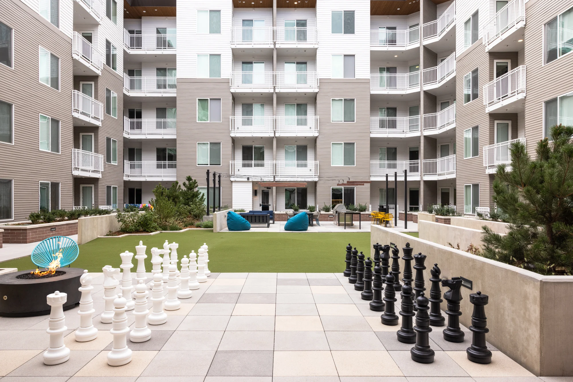 Outdoor communal area with large chess pieces and leisure spaces.