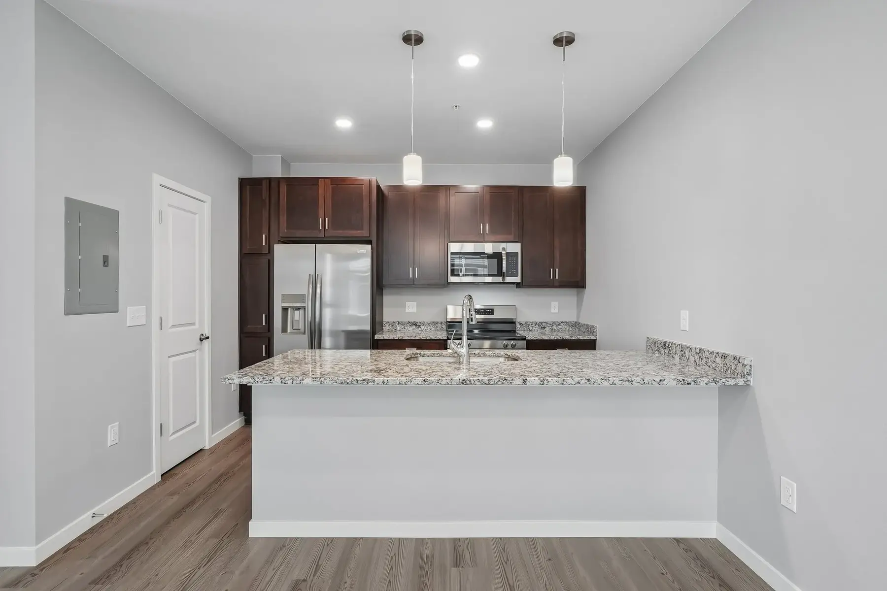 Contemporary Kitchen Interior An inviting kitchen featuring dark wood cabinetry, granite counter tops, and stainless steel appliances.