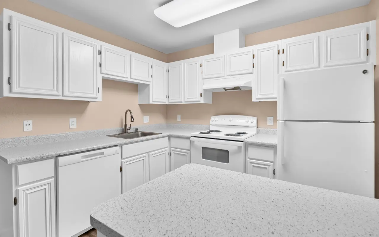 A modern kitchen featuring white cabinets, a white countertop, and stainless steel appliances including a stove and refrigerator.