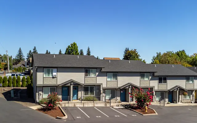 A row of townhouses in a residential area with blue skies.
