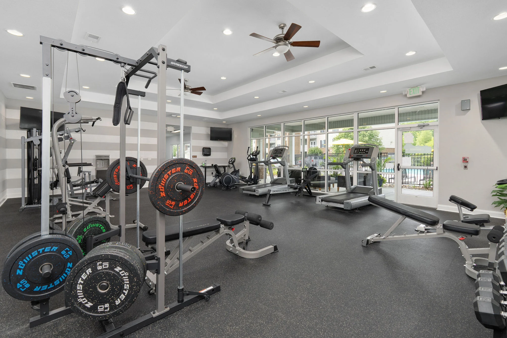 Modern Gym Facility A modern gym with weightlifting equipment, treadmills, and large windows for natural light.