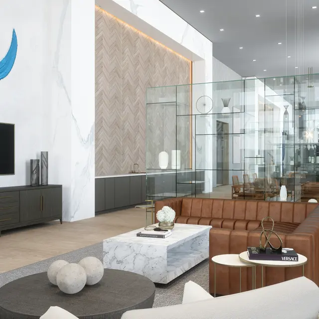 A contemporary living area featuring a spacious layout with a glass room, light wooden flooring, and stylish furniture. The room includes a large TV, decorative wall art, and several potted plants.