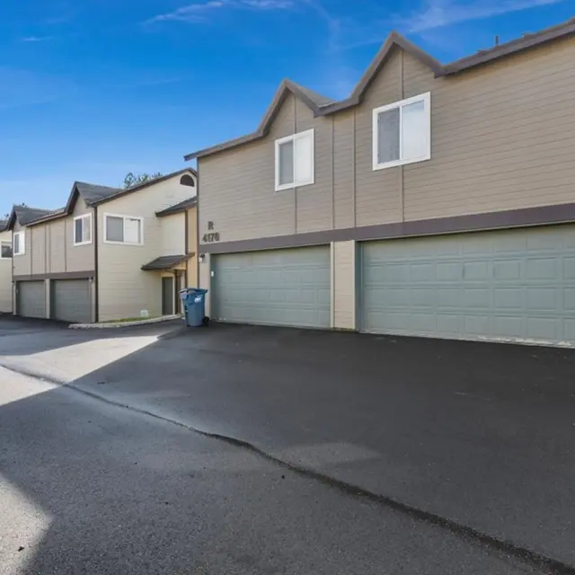 Monterra Townhomes - Townhouse Complex View of a townhouse complex with a paved driveway and garages.