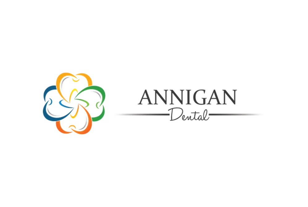 A logo featuring a colorful abstract design alongside the text 'ANNIGAN Dental'. The graphic is composed of interlocking shapes in orange, yellow, green, and blue, suggesting a connection or unity. The text is elegant and professional, emphasizing the dental practice.