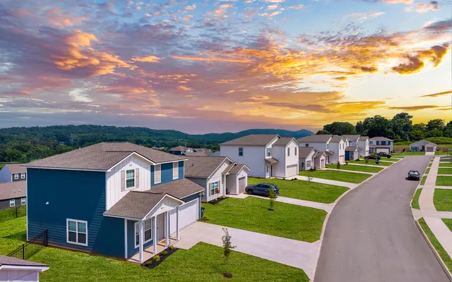 A serene suburban neighborhood with modern houses and a beautiful sunset sky.