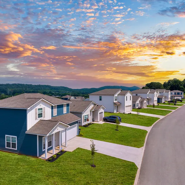 A serene suburban neighborhood with modern houses and a beautiful sunset sky.