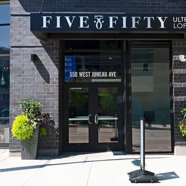 Facade of a modern building with large glass doors and a sign that reads 'FIVE FIFTY ULTRA LOFTS'.
