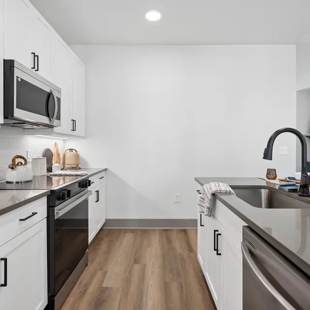 Contemporary Kitchen Design A modern kitchen with white cabinetry, stainless steel appliances, and a dark countertop.