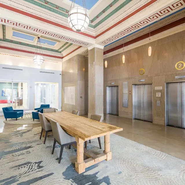 Elegant Elevator Lobby Elevator lobby with seating, large wooden table and elevators in a stylish design.
