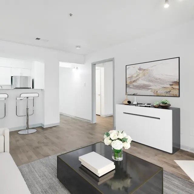 A modern living room featuring a white couch, coffee table, and a sleek media console.