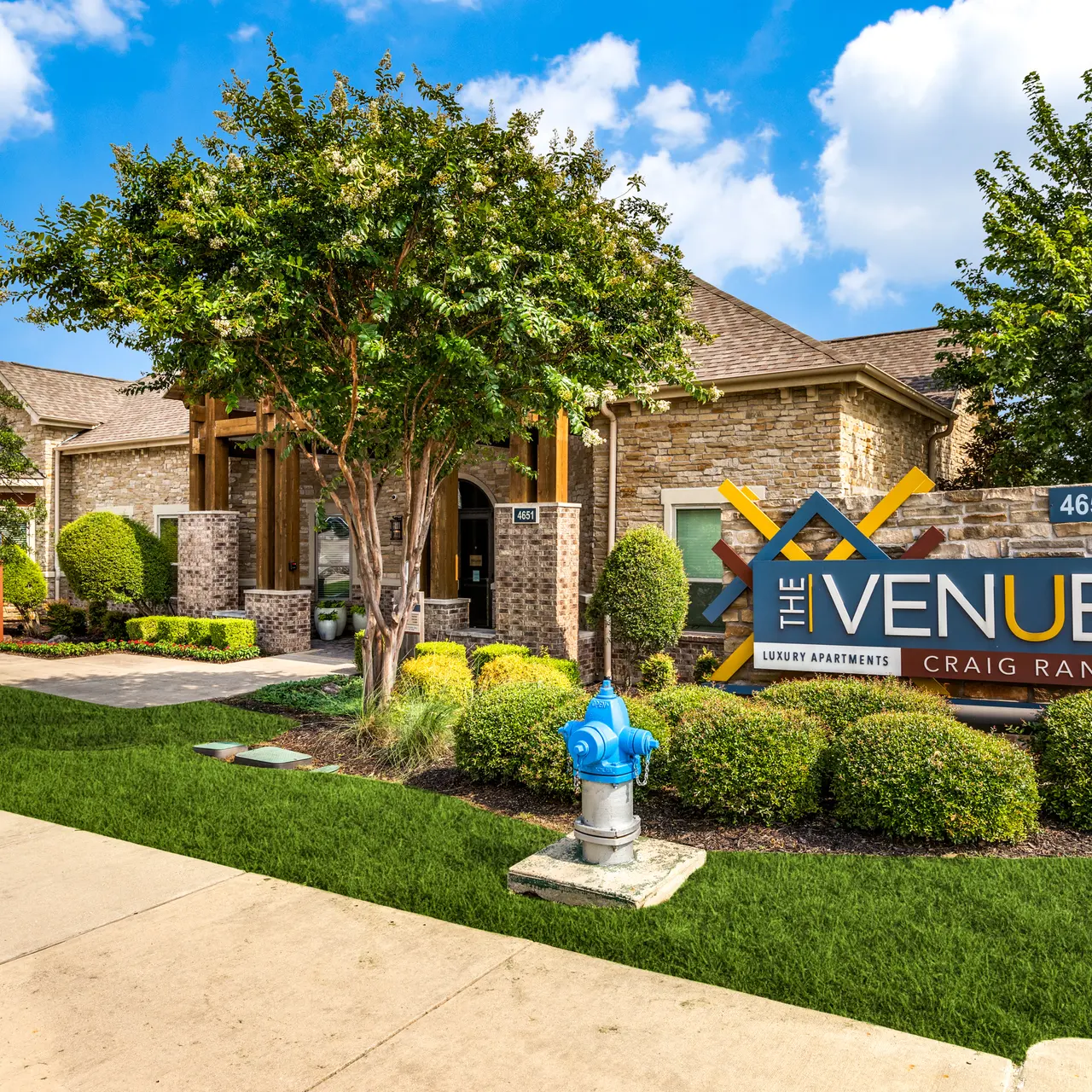 Facade of The Venue at Craig Ranch, showing landscaped grounds, a sign, and a well-maintained entrance.