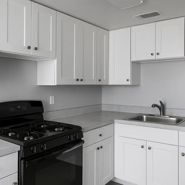 Modern Kitchen Interior A modern kitchen featuring white cabinets, a black gas stove, and a stainless steel sink on a light gray countertop.