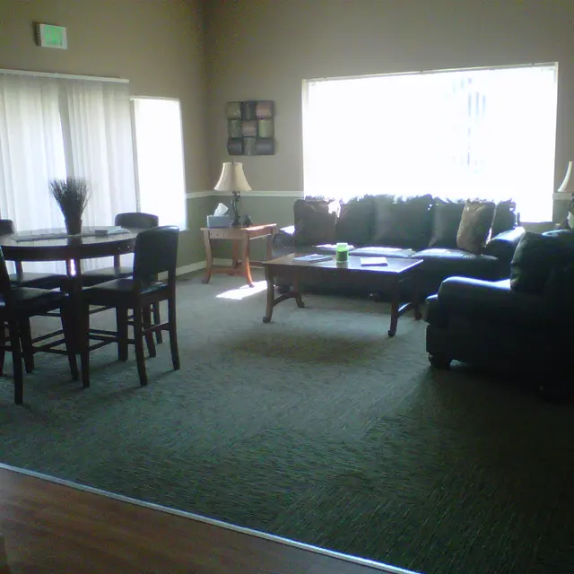 Cozy Living Room Interior A cozy living room featuring a seating area with a dark sofa, a coffee table, and an adjacent dining table.