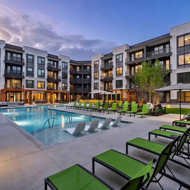 Modern Apartment Pool Area Outdoor pool area with lounge chairs and modern apartment buildings in the background.