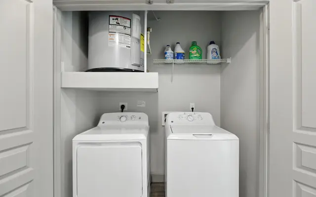 A compact laundry area featuring a washing machine and dryer side by side, with cleaning supplies on a shelf above.