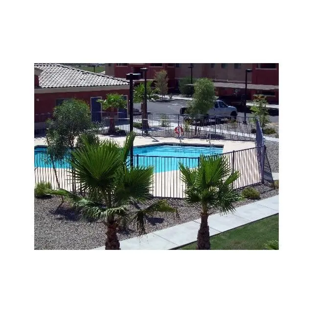 Aerial view of a swimming pool area surrounded by palm trees and landscaped grounds.