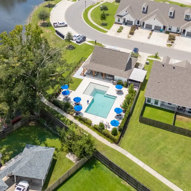 Aerial View of Neighborhood with Pool Aerial view of a neighborhood featuring a swimming pool, surrounding houses, and a pond.