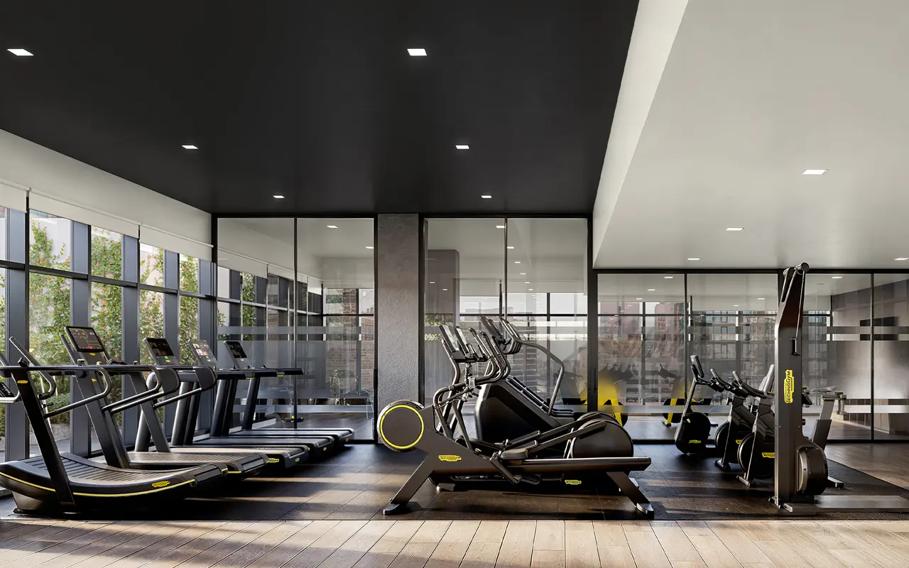 A modern gym interior featuring various exercise machines such as treadmills and elliptical trainers, with large windows letting in natural light and a sleek design.
