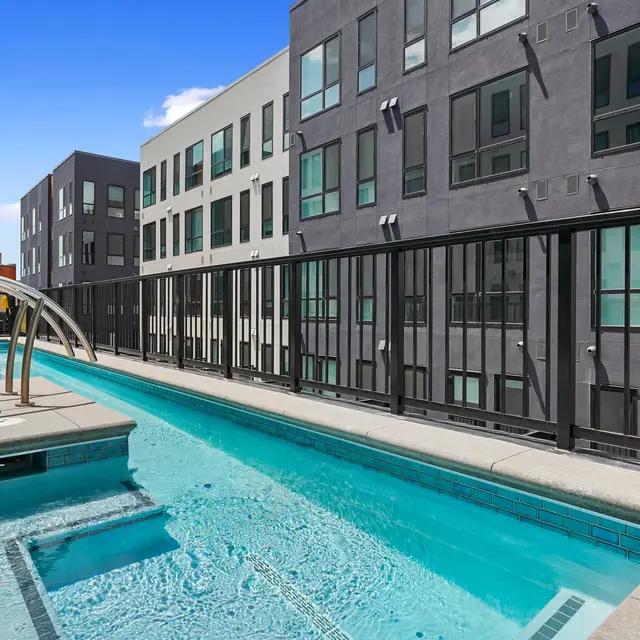Contemporary Apartment Pool Area A sleek swimming pool surrounded by contemporary apartment buildings, featuring a light blue water surface and modern architectural details.