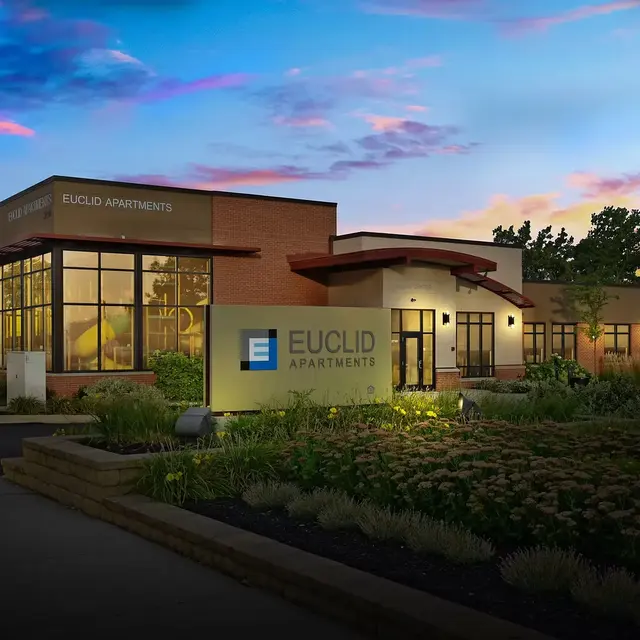 Exterior view of Euclid Apartments building during twilight, showcasing modern architecture with a landscaped garden.