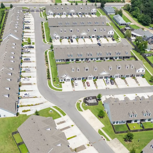 Aerial View of Residential Apartment Complex Aerial view of a residential apartment complex with multiple buildings, parking spaces, and green areas.