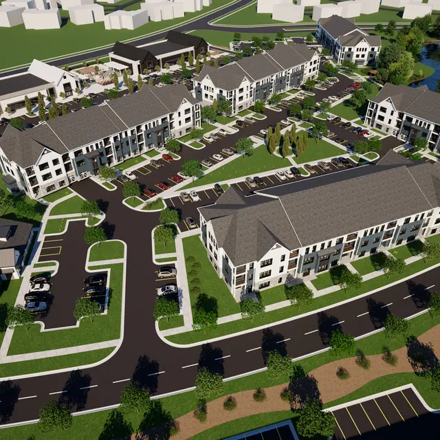 Aerial view of a modern apartment complex with two-story buildings, landscaped green areas, a pool, and parking spaces.