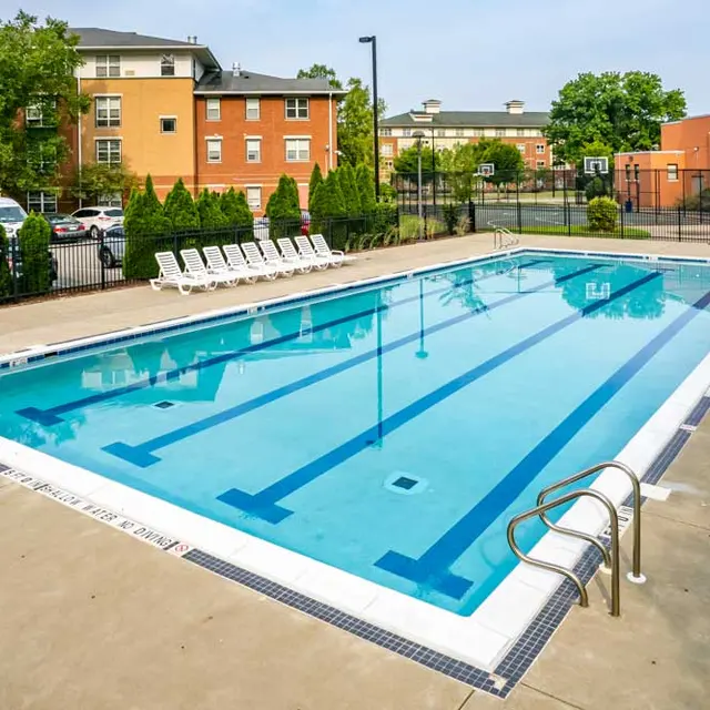 Community Swimming Pool A clean, inviting swimming pool with clear water, surrounded by lounge chairs and well-maintained greenery.