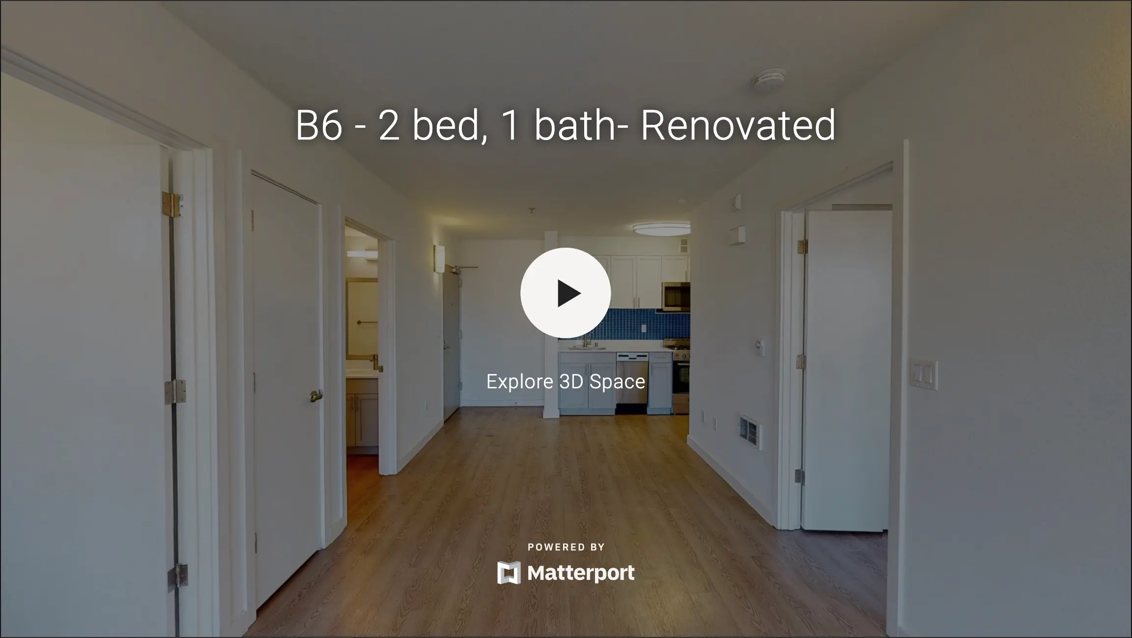 Interior view of a renovated apartment featuring two bedrooms and one bathroom, showing an open layout with visible kitchen area.