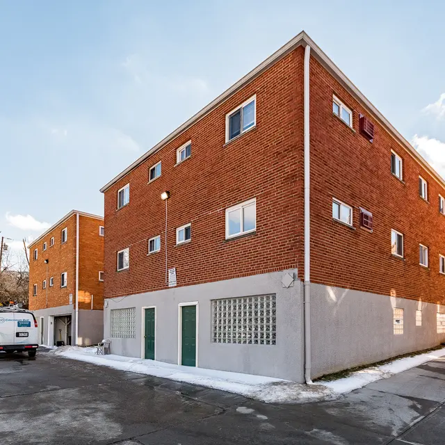 Brick Apartment Building Exterior Exterior view of a multi-story brick apartment building with windows and a snowy ground