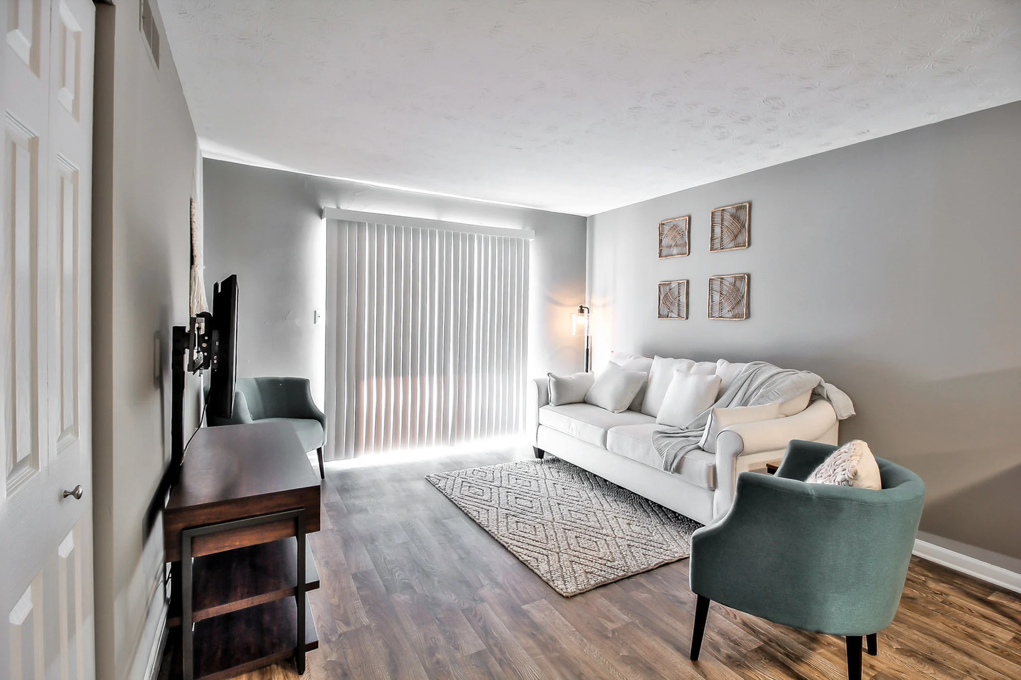 Cozy Modern Living Room A modern living room with a cozy sofa, accent chairs, and a television set against the wall.