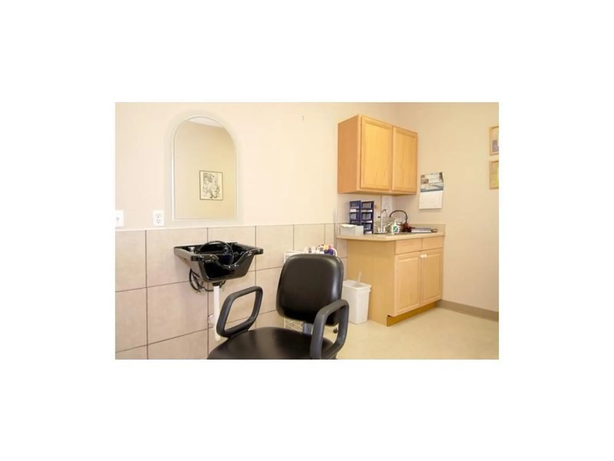 Salon room with styling chair,wash basin,mirror and cabinetry.